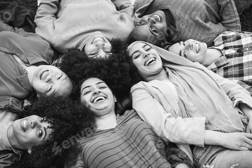Preview: Happy diverse female friends having fun lying together in circle outdoor