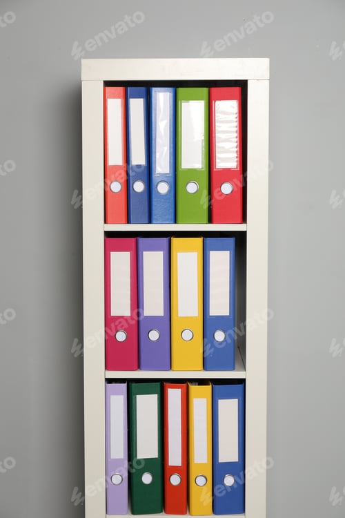 Preview: Colorful binder office folders on shelving unit near light grey wall