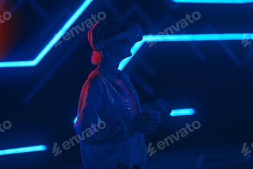 Preview: Young woman playing VR game in neon room.