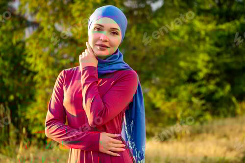 Preview: Islamic beautiful woman in a Muslim, virgin dress standing on a summer park