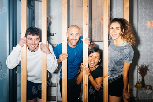 Preview: Group of happy diverse sportspersons in gym near wooden fence