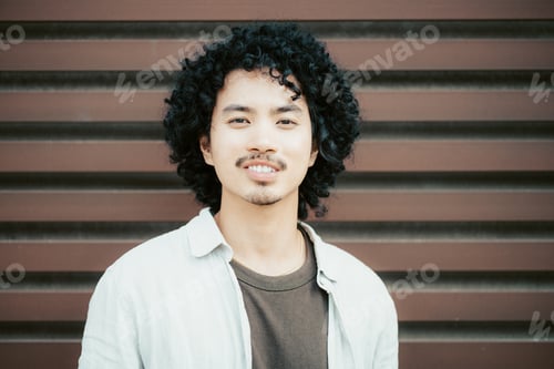 Preview: Curly-haired guy smiling subtly