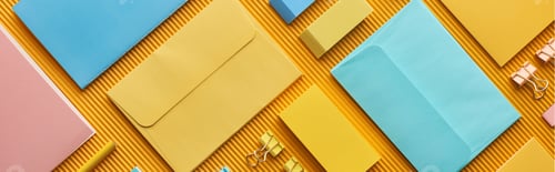 Preview: panoramic shot of colorful organized office stationery supplies on yellow