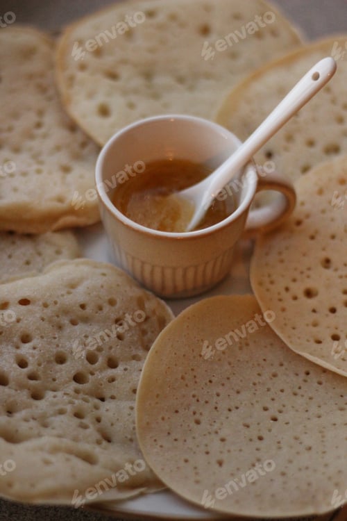 Preview: A plate of Baghir pancakes from Moroccan cuisine and a small cup with honey for them