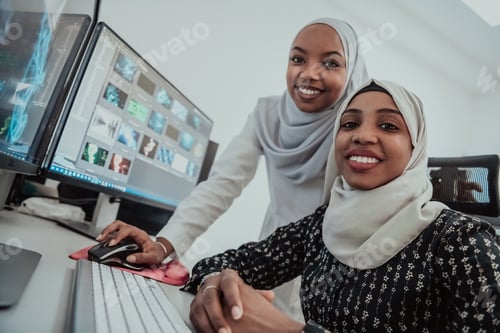 Preview: Friends at the office two young Afro American modern Muslim businesswomen wearing scarf in creative