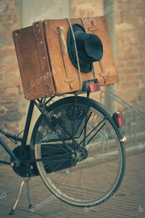 Preview: Black hat and brown suitcase on old bike