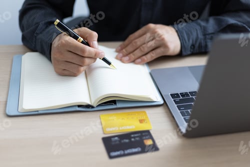 Preview: Man writing credit card expense record. Financial planning and cost reduction.