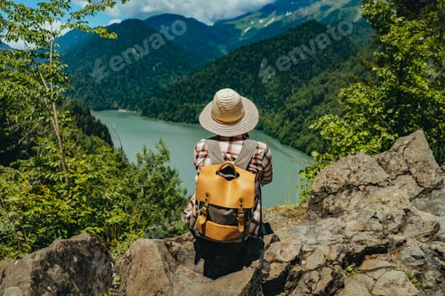 Preview: Hiking traveller woman with backpack enjoying beautiful view of turquois blue Lake Ritsa in Abkhazia