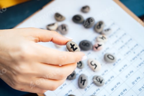 Preview: Woman numerologist hand with pebble stone with number seven 7