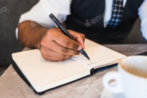 Preview: Hispanic businessman writing in a notebook