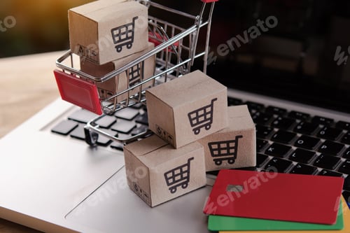 Preview: cardboard box with a shopping cart logo in a trolley on laptop keyboard.