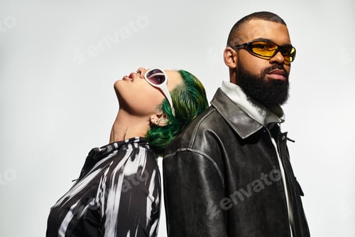 Preview: Stylish multicultural couple showcasing trendy sunglasses in creative studio setting