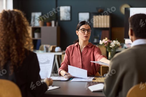 Preview: Caucasian Woman Handing Document to Diverse Young Adults in Office
