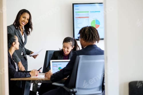 Preview: Businessman and businesswomen, in office meeting, using laptop, looking at data