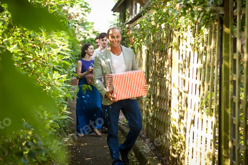 Preview: A joyful group of friends walking along a lush garden path
