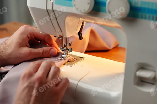 Preview: Hands sewing fabric using a sewing machine on a wooden table in a well-lit workspace