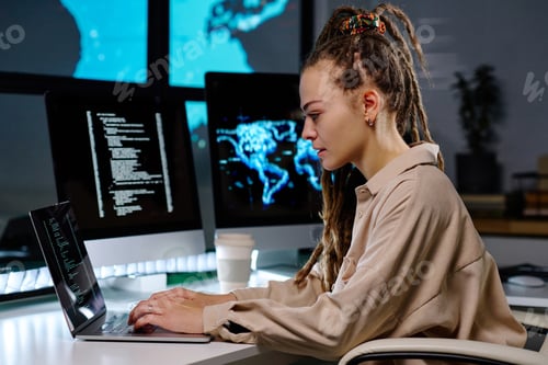 Preview: Young serious female IT manager typing on laptop keyboard in office