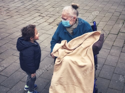 Preview: Child and Senior Talk on a Brick Sidewalk