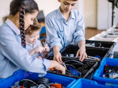 Preview: Group of kids choose parts of robotic toys for building robots at school lesson