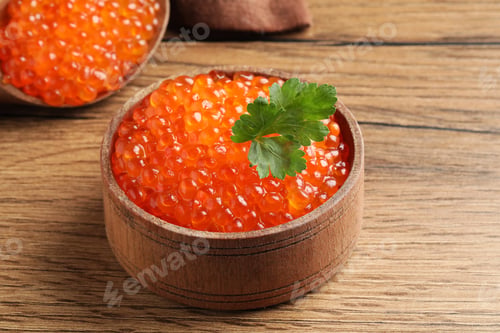 Preview: Bowl with delicious red caviar and parsley leaf on wooden table