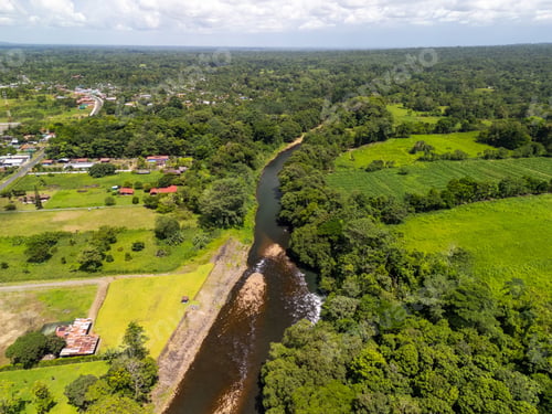Preview: Aerial view of a lush green landscape with a river flowing through.