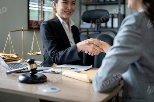 Preview: Gavel Justice hammer on wooden table with judge and client shaking hands after adviced in