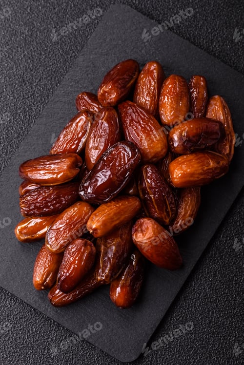 Preview: Dried dates on a ceramic plate for Ramadan or Iftar. Dates fruit as a background