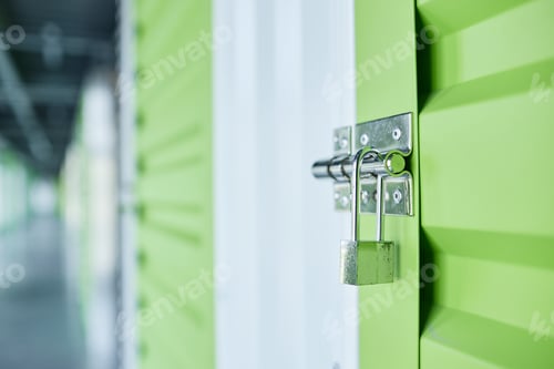 Preview: Metal Latch on Green Door Leading to Self Storage Unit Closed on Lock