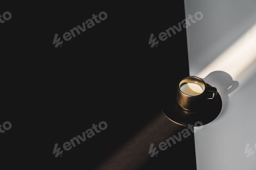 Preview: high angle view of cup of milk in black cup on black and white surface with sunlight