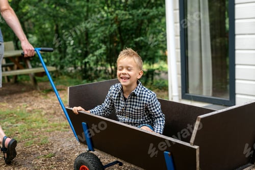 Preview: A man pulling a wooden wagon with his son.