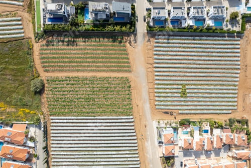Preview: Aerial drone view of greenhouses in a row, and holiday houses. Food cultivation Farming, bio
