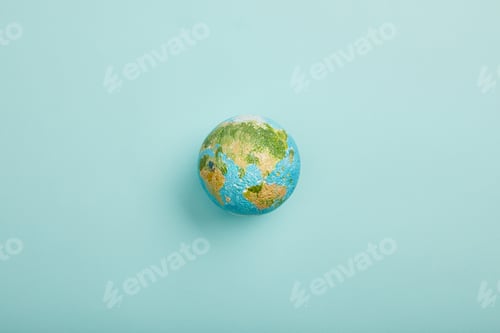 Preview: top view of planet model on turquoise background, earth day concept