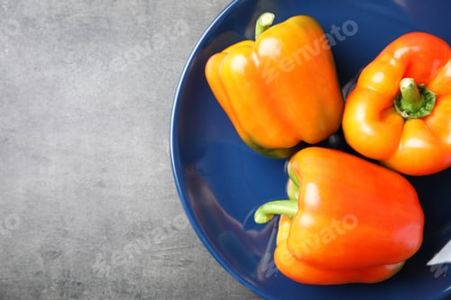 Preview: Plate with ripe paprika peppers on grey background, top view