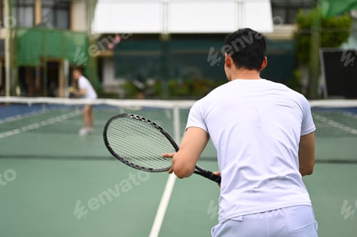 Preview: Back view of male tennis player focused in ready position to receive a serve.
