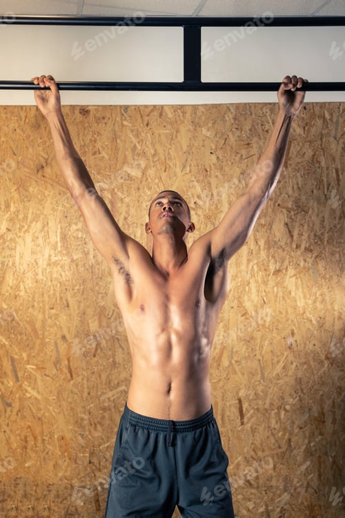 Preview: Black man doing pull up exercise on crossbar