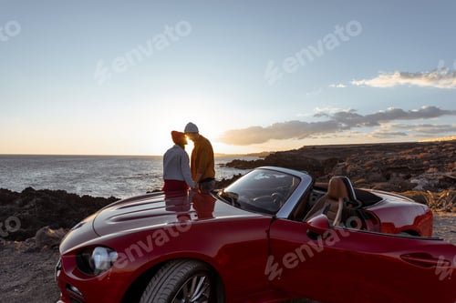 Preview: Lovely couple on the beach near the car on a sunset
