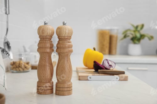 Preview: Wooden salt and pepper shakers on white countertop in kitchen, space for text