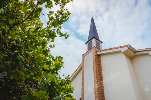 Preview: Building facade of a traditional American Protestant church with clock tower and blue sky.