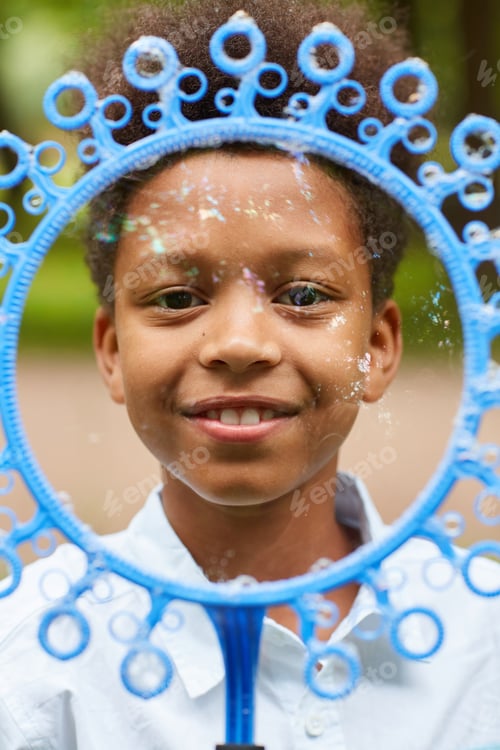 Preview: Smiling African Boy Holding Bubble Wand