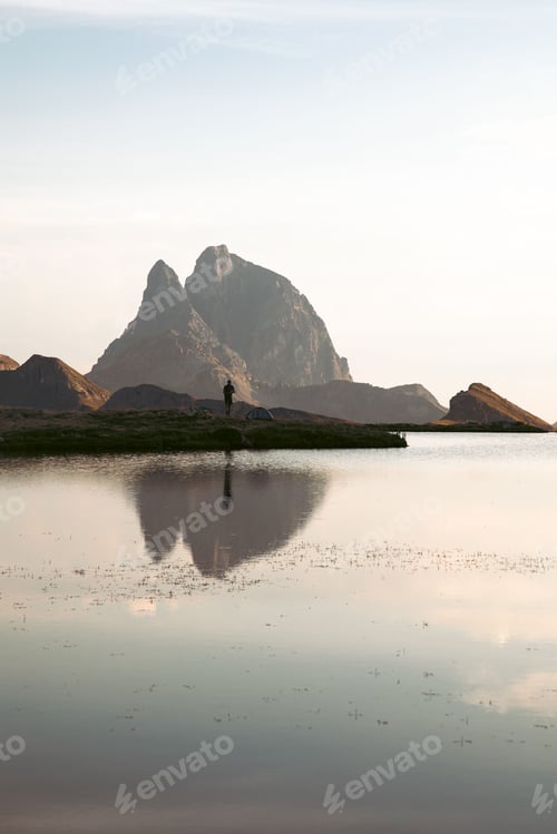 Preview: Vertical shot of Pic du Midi d'Ossau mountain peak with reflection on a lake at sunset