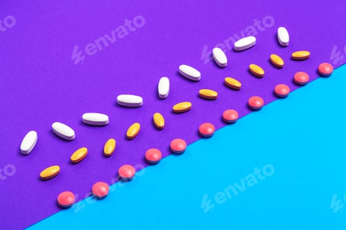 Preview: A pile of multicolored pills on blue background. Top view