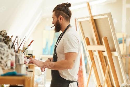 Preview: Cheerful Bearded Artist Working in Studio