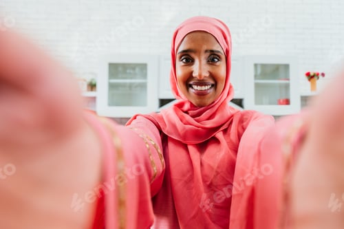 Preview: Happy and beautiful middle eastern woman wearing traditional arab clothing at home