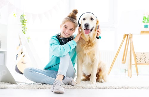 Preview: Happy girl holding headphones on dog