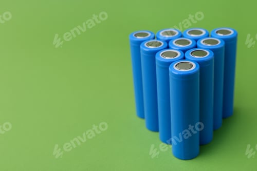 Preview: Many AA cell batteries on green background, closeup. Space for text