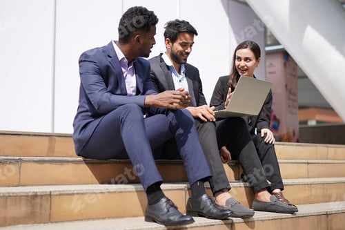 Preview: group of young business people chatting and using tablet device at outside of start up office.
