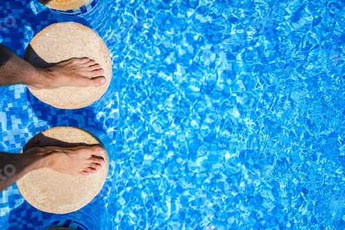 Preview: Feet of a swimmer in a pool during his summer vacation.