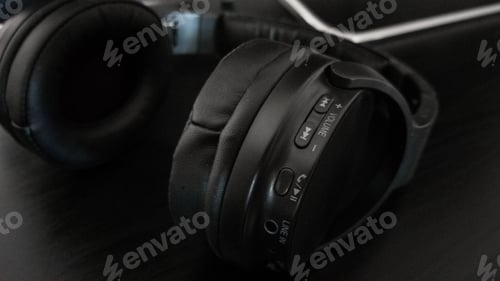 Preview: Close-up of black headphones on black background.