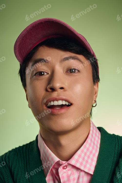 Preview: Stylish asian man showcases unique fashion in vibrant studio space