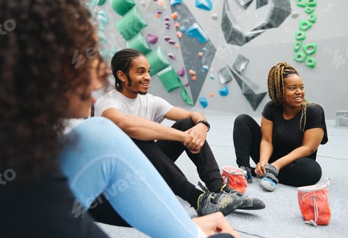 Preview: Multi-Cultural Group Watching Friend On Climbing Wall In Indoor Activity Centre